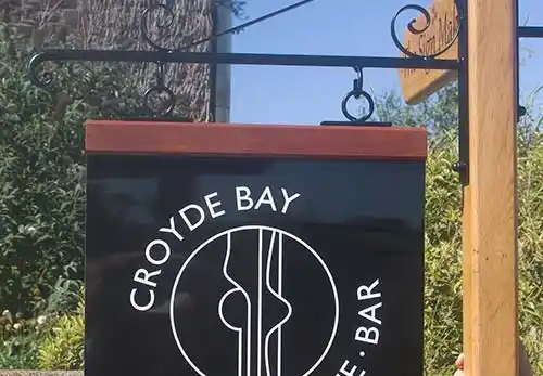 A metal hanging sign with a hardwood header.